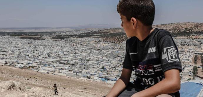 Un garçon devant un campement en Syrie