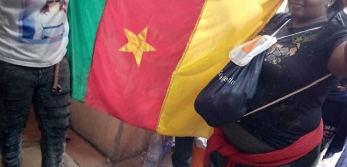 Des personnes qui tiennent le drapeau du Cameroun