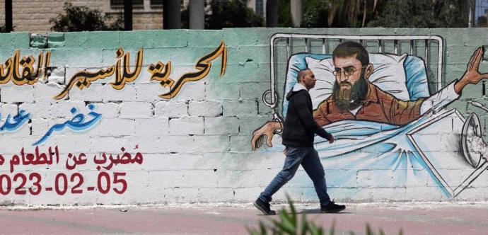 Homme qui marche dans la rue, avec une fresque murale