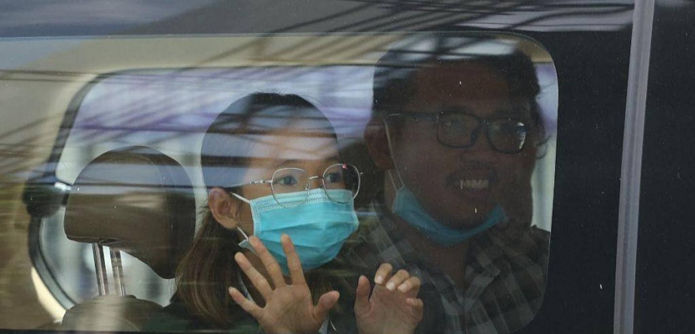 Sun Ratha salue sa famille de la vitre d'une voiture, alors qu'elle est emmenée à la Cour municipale de Phnom Penh