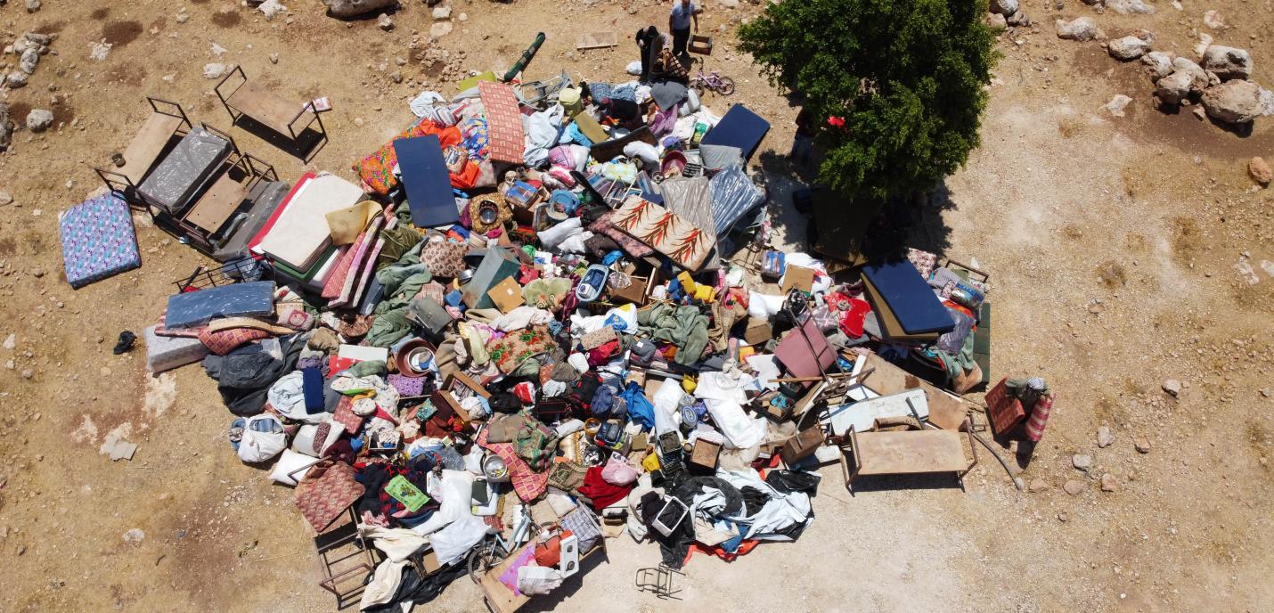 Les effets personnels d’une famille palestinienne sont rassemblés pêle-mêle sur le sol. Ils proviennent du logement de cette famille, démoli dans la journée par les forces israéliennes dans le village d’Umm Al Khair, en Cisjordanie occupée, le 9 août 2016