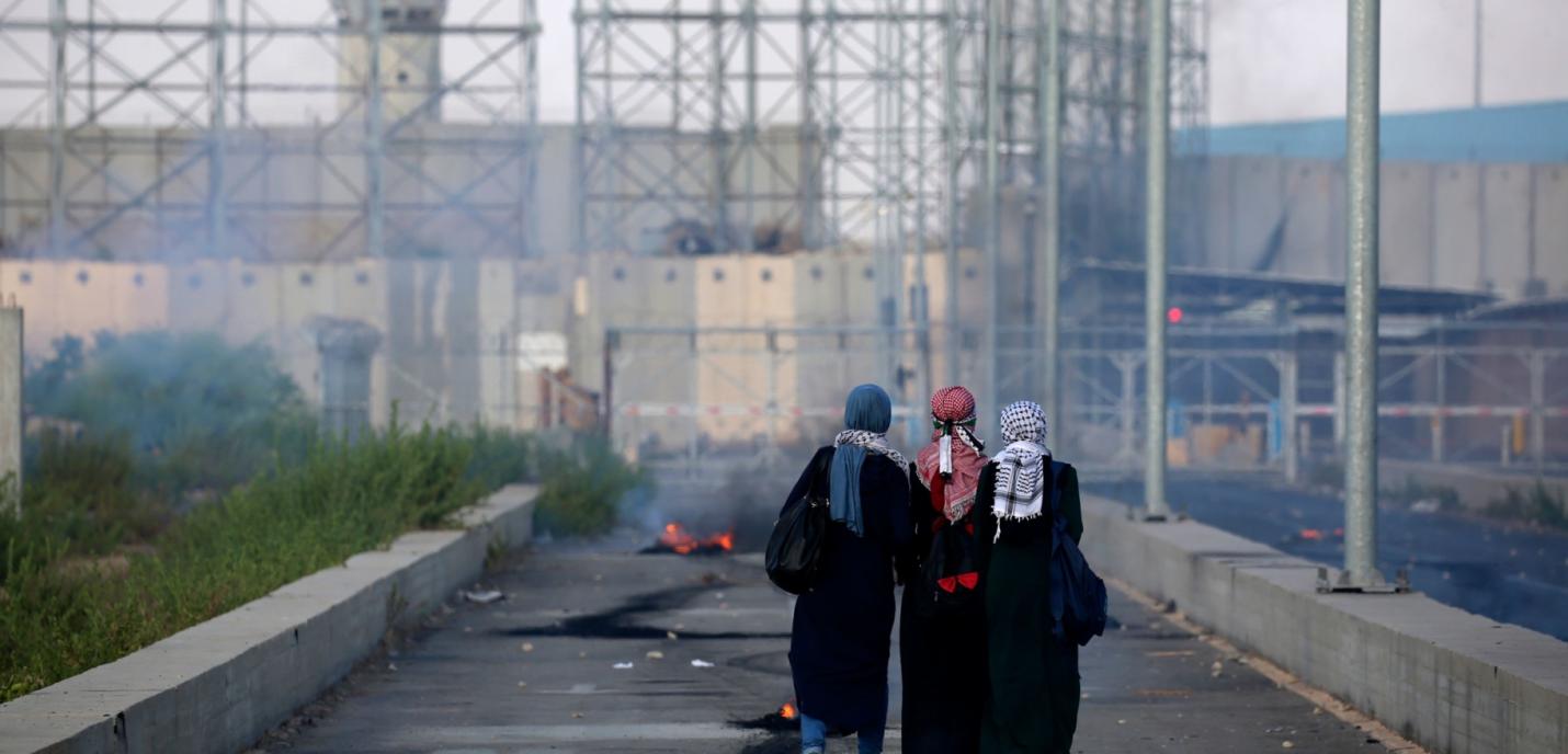 3 femmes se trouvent devant un immeuble en ruine