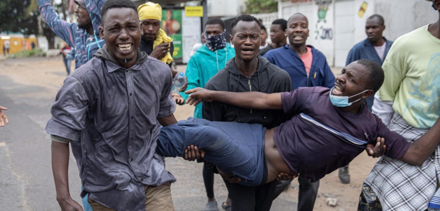 Manifestant blessé porté par d'autres hommes