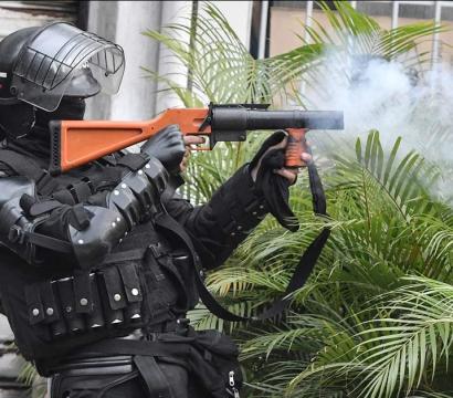Une personne habillée en uniforme d'opération tactique lance un projectile.