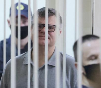 Viktar Babaryka se tient derrière des barreaux blancs de prison.