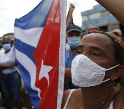 une manifestation à Cuba. Une personne tient le drapeau cubain.