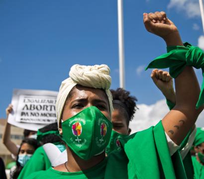 Une manifestante au point levée portant du vert.