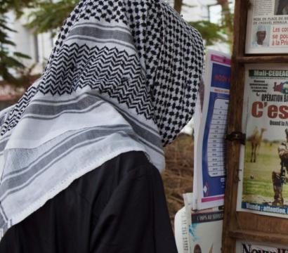 Une personne devant des journaux