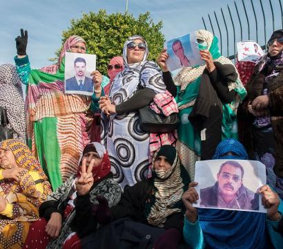 Des personnes qui manifestent avec des photos des personnes incarcérées. 