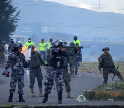 Des militaires et la police avec un militaire qui pointe son arme