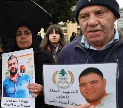 Des manifestants avec des pancartes et des photos des victimes