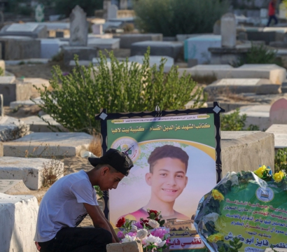 Un jeune qui se recueille sur la tombe d'un autre jeune