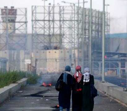 3 femmes se trouvent devant un immeuble en ruine