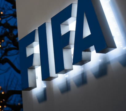 Le logo épelant FIFA est situé à droite, tandis qu'en arrière-plan se dresse un arbre illuminé.