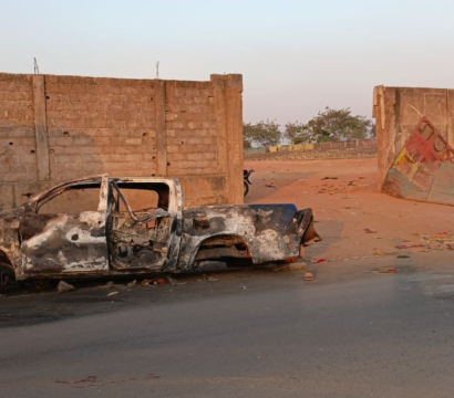 Une voiture brûlée au bord d'une route