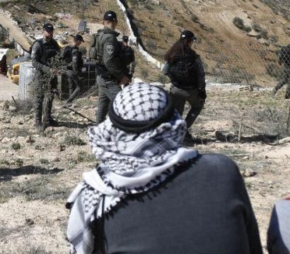 Soldats devant personnes palestiniennes